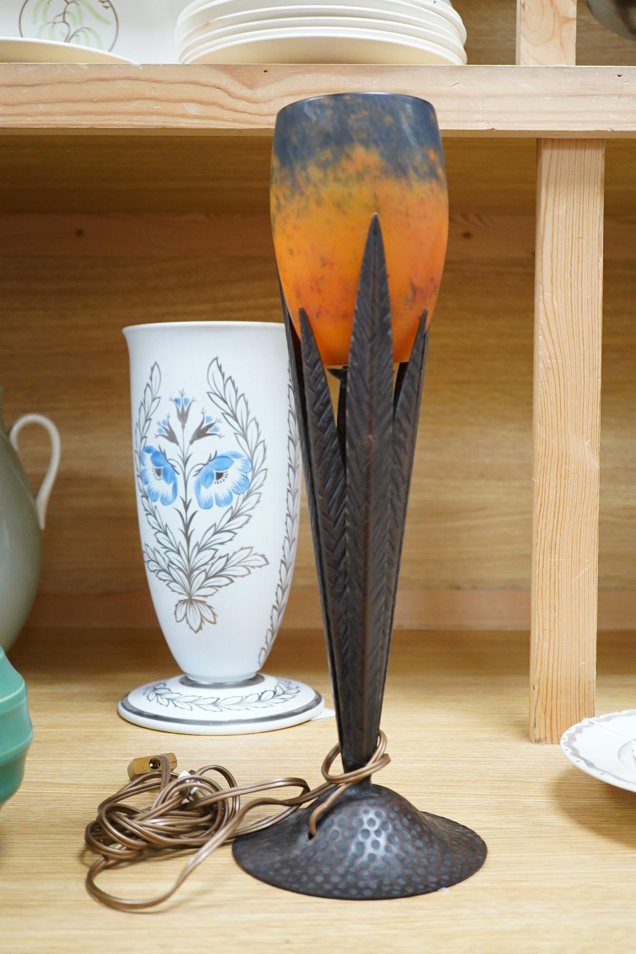 Manner of Muller Freres and Robj: A French Art Deco table lamp the mottled orange glass shade supported by naturalistic palm-leaf metal supports terminating in a circular hammered metal base, 40cm high